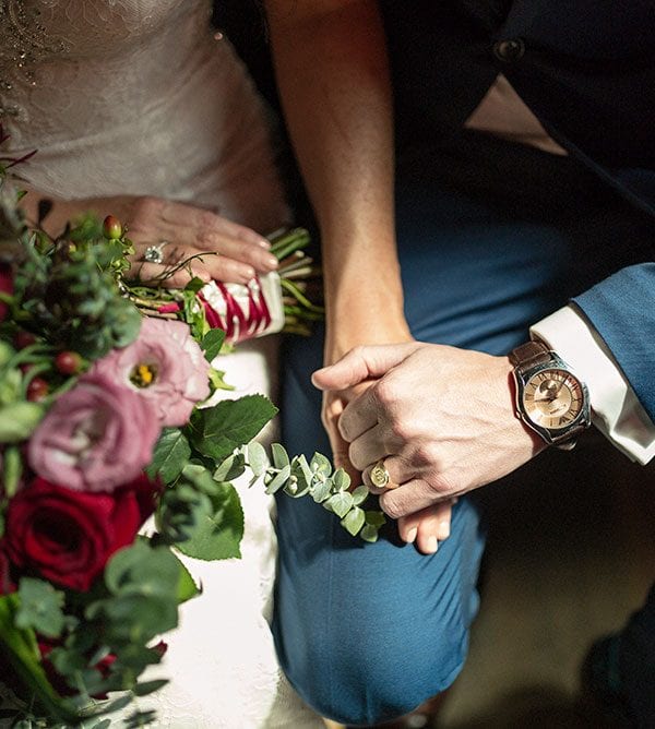 Bride and groom hold hands. Bouquet by Kim Chan Events
