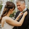 Bride pinning a button hole on her father