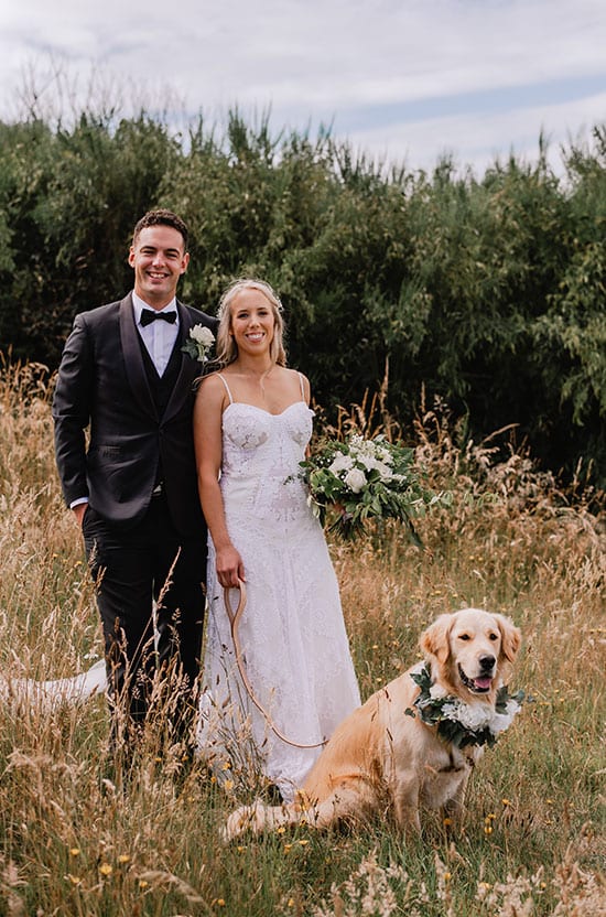 Bride and groom with their dog and bouquets